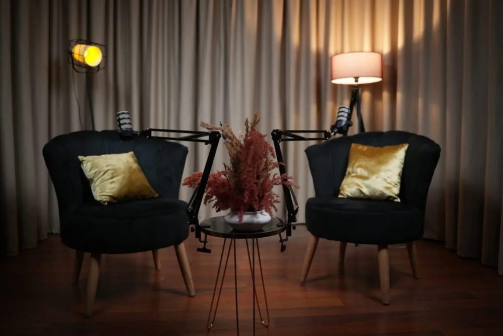 Plateau de podcast avec deux fauteuils, des lampes et une petite table